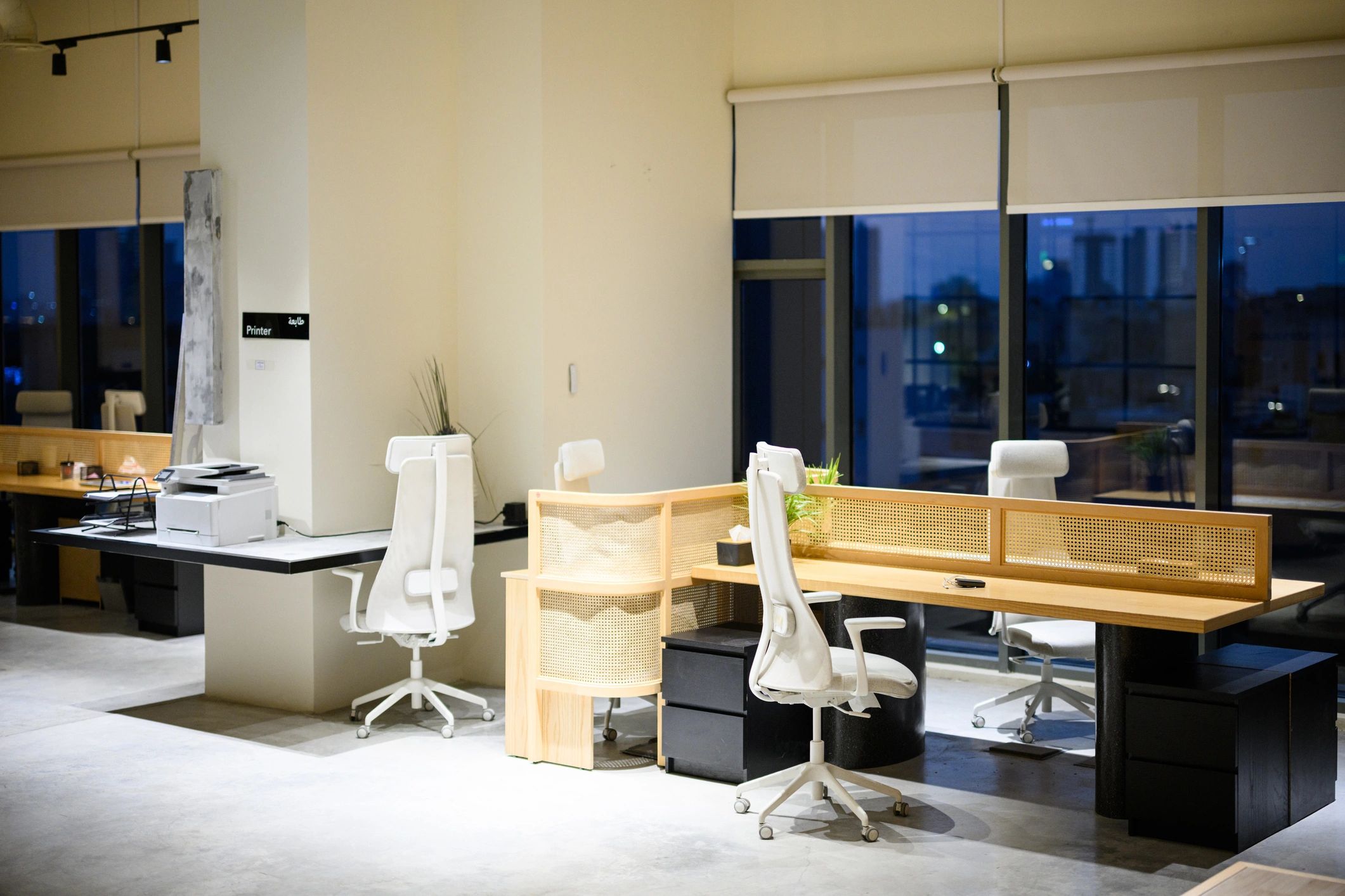 Modern newsroom-style workspace with desks and screens